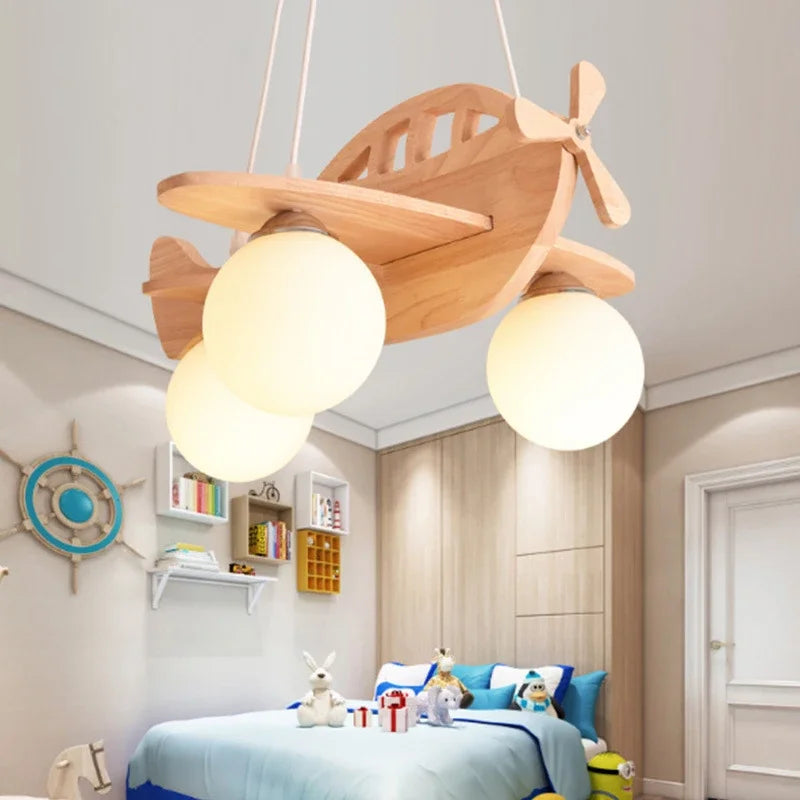 DecorBites kids natural wood airplane chandelier with two warm globe LEDs in a nursery on Tampa Home & Garden Store