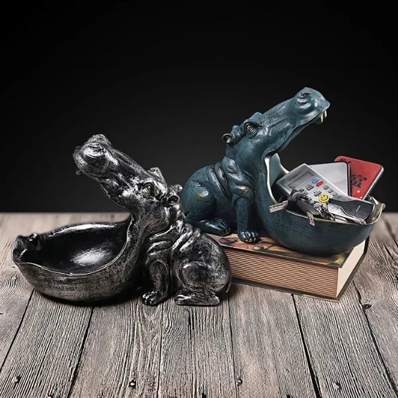 Hippo statue decor: glossy black candy dish and blue-green storage container with keys on a book on Tampa Home & Garden Store