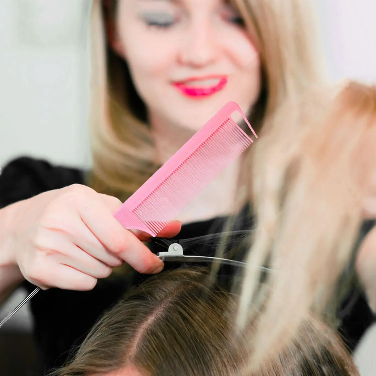 pink plastic scalp massage comb held by stylist during hair styling on Tampa Home & Garden Store
