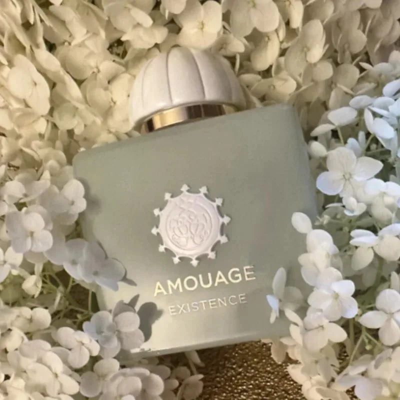AMOUAGE EXISTENCE perfume bottle in frosted glass with metallic cap and gold crest among flowers on Tampa Home & Garden Store