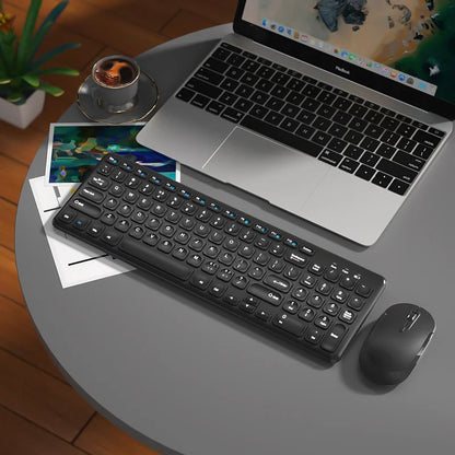 Wireless keyboard and mouse set with black keyboard and mouse on a gray table beside a silver laptop on Tampa Home & Garden Store
