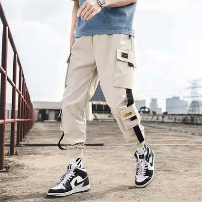 Men's beige cargo joggers with cargo pockets and strap accents, cuffed hems, sneakers on Tampa Home & Garden Store