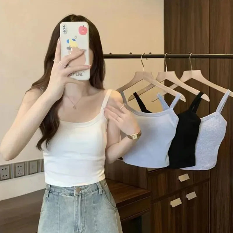 Women crop top sleeveless camisole in white; model in shorts, selfie with tops on hangers on Tampa Home & Garden Store
