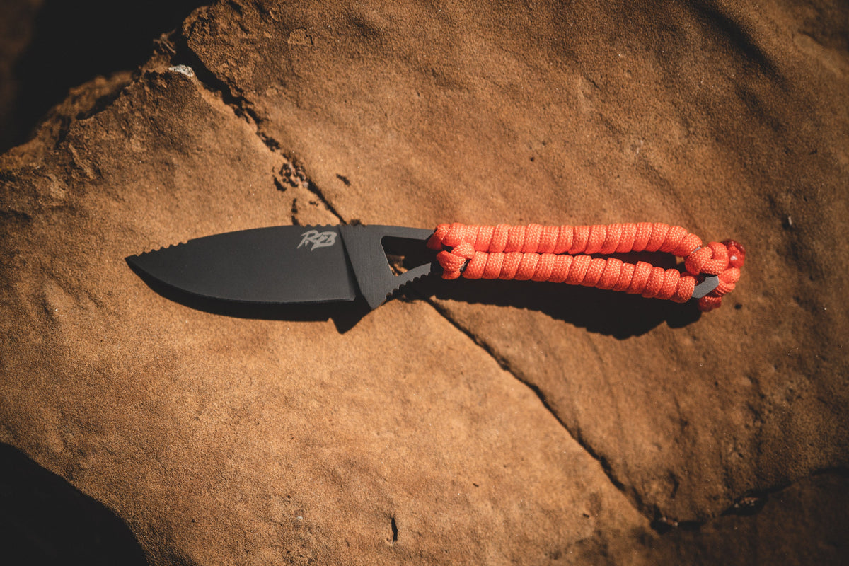 Ultralight Ridge Blade knife by Ridge Belts with black blade and orange paracord handle on rock on Tampa Home & Garden Store