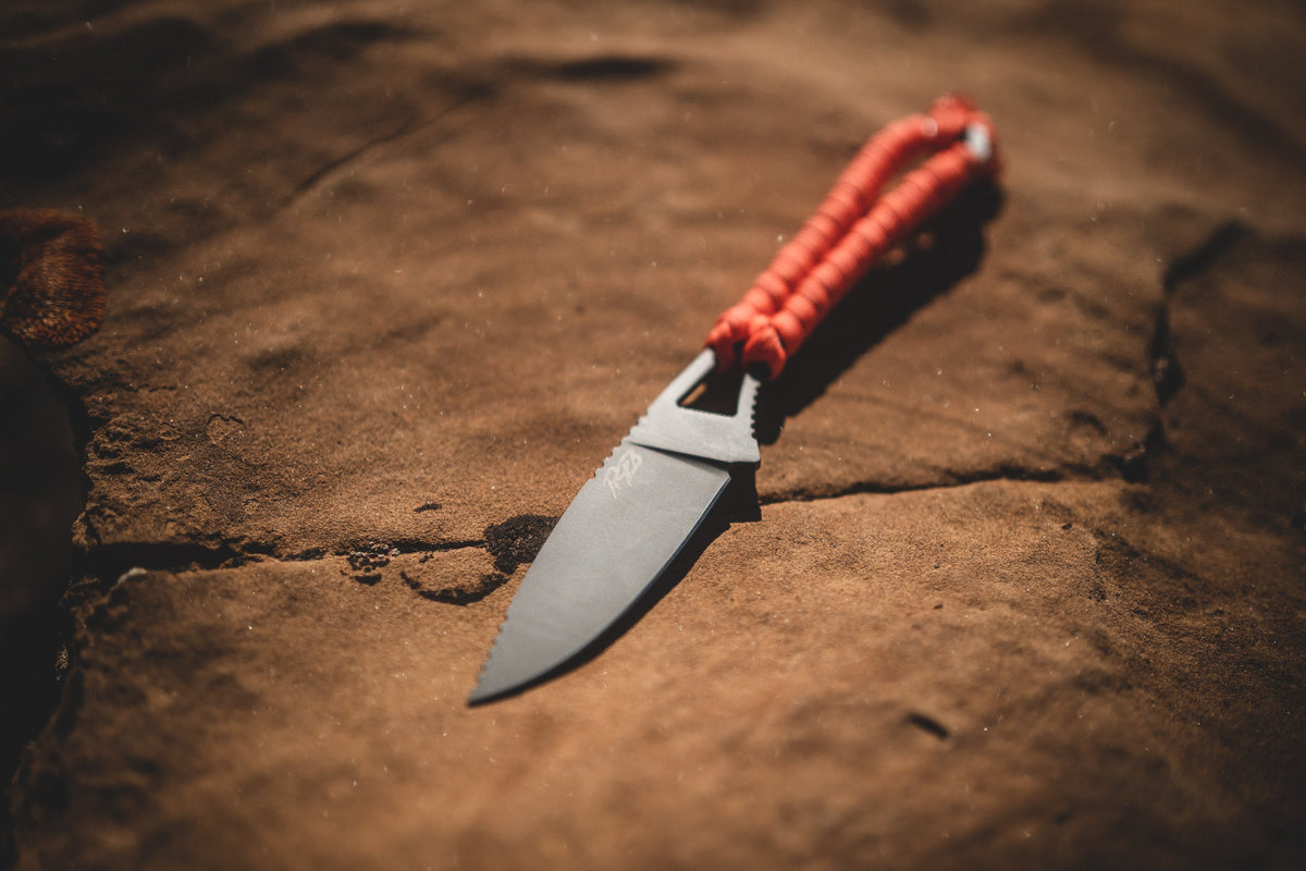 Ridge Belts Ultralight Ridge Blade knife with red paracord handle on rocky surface on Tampa Home & Garden Store