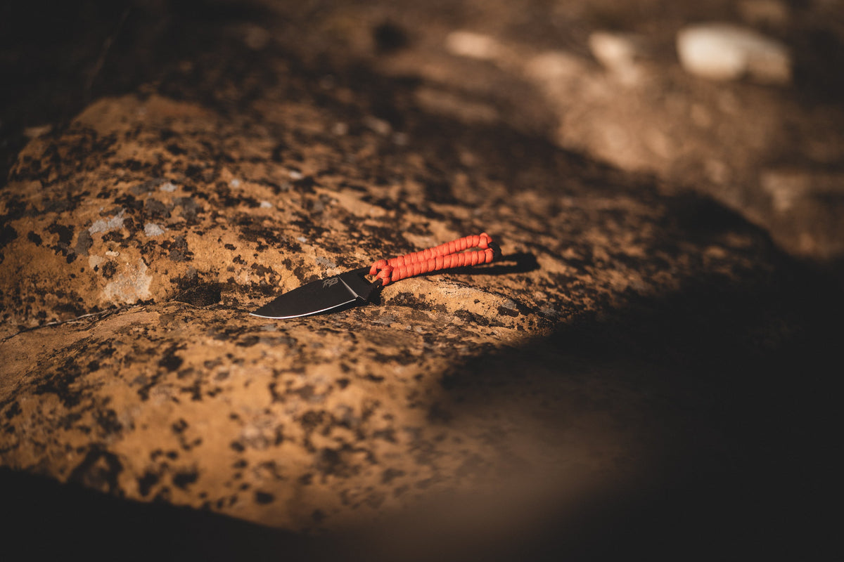 Ultralight Ridge Blade knife by Ridge Belts with orange paracord handle on rocky surface on Tampa Home & Garden Store