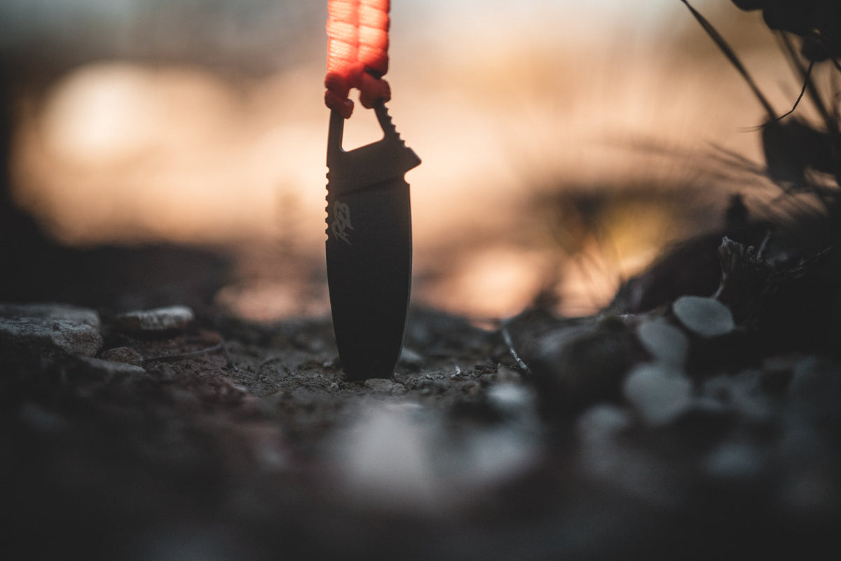 Ultralight Ridge Blade knife by Ridge Belts with black blade and red lanyard at sunset on Tampa Home & Garden Store