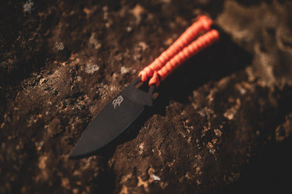 Ultralight Ridge Blade knife with orange paracord wrap on rugged rock surface by Ridge Belts on Tampa Home & Garden Store