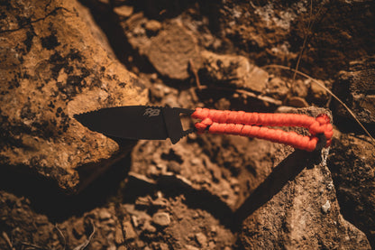 Ultralight Ridge Blade knife by Ridge Belts with black blade and orange paracord handle on rocks on Tampa Home & Garden Store
