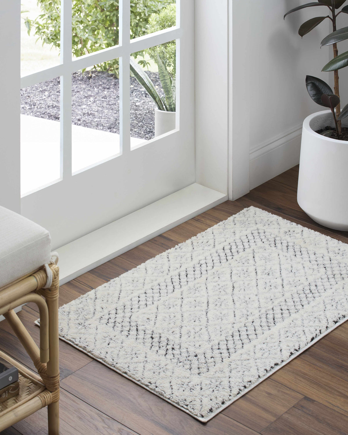 Julio Area Rug by Boutique Rugs, cream rug with black linear pattern on wood floor on Tampa Home & Garden Store