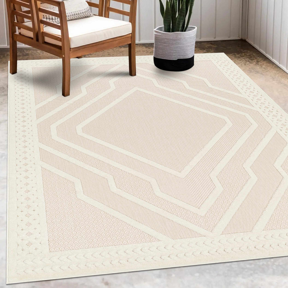 Anja Cream Outdoor Rug by Boutique Rugs, geometric hex border near wooden chair on Tampa Home & Garden Store
