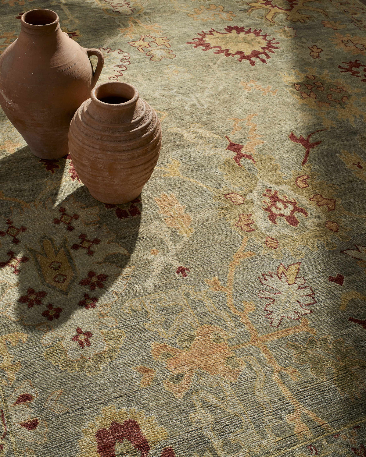 Cian Area Rug Boutique Rugs, beige earth-toned vintage motif; two terracotta vases on Tampa Home & Garden Store