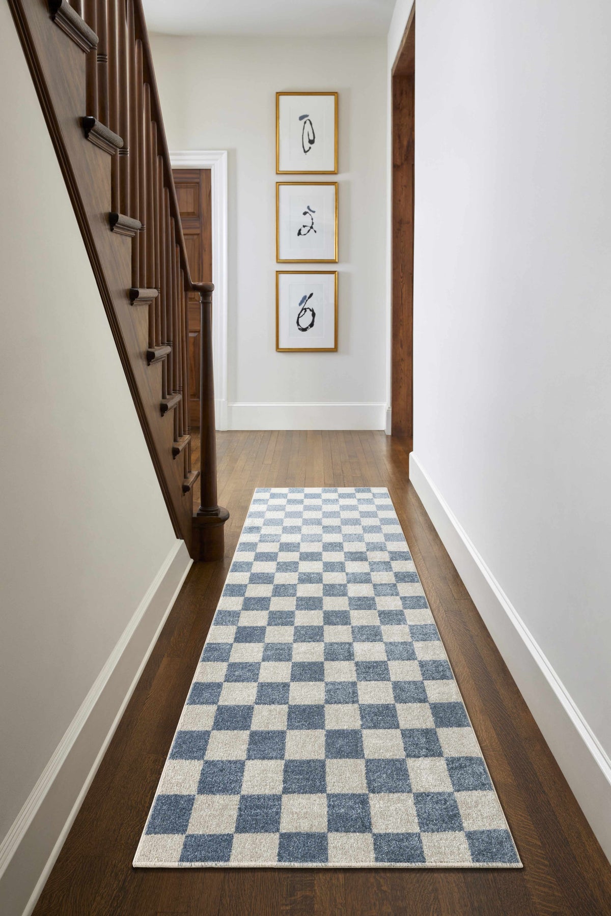 Brone Blue Checkered Washable Rug by Boutique Rugs in a hallway beside a staircase on Tampa Home & Garden Store
