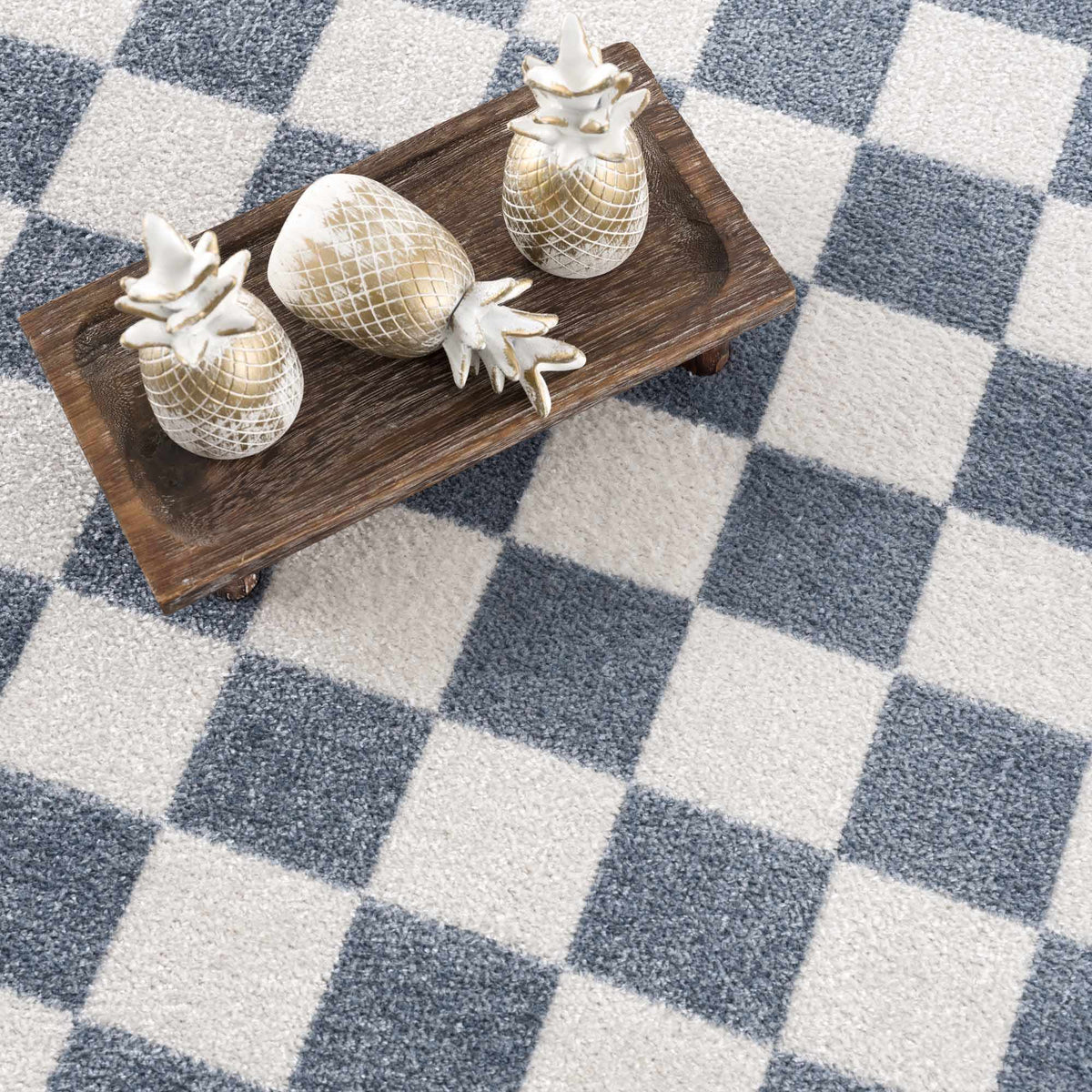 Brone blue checkered washable rug with blue and ivory squares on a wooden tray with pineapples on Tampa Home & Garden Store