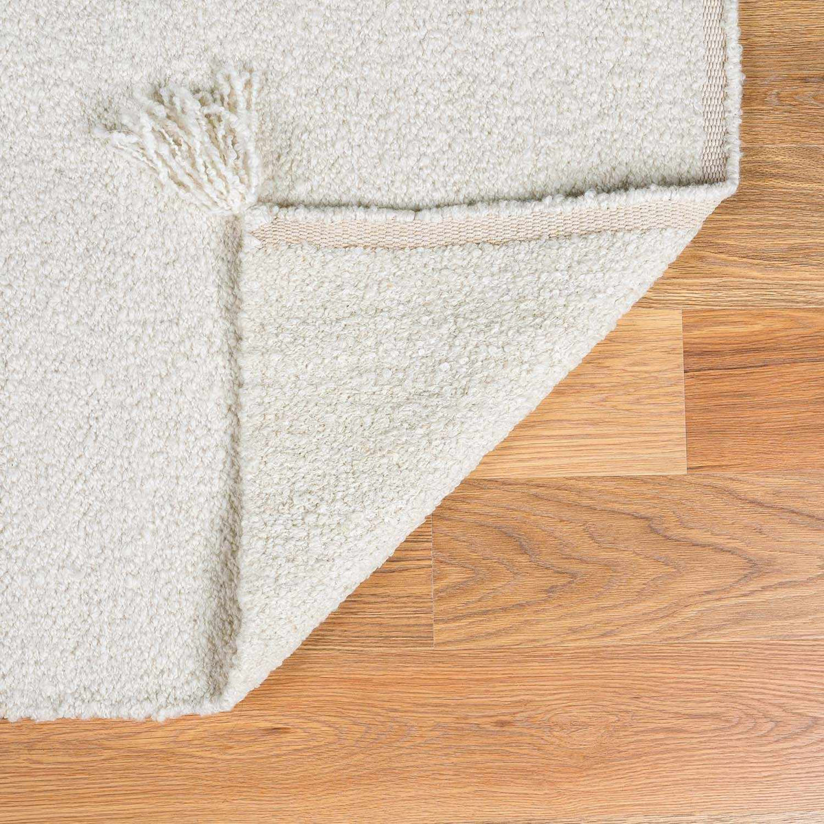 Niabi Area Rug ivory shag with plush pile and folded corner on wood floor Boutique Rugs on Tampa Home & Garden Store