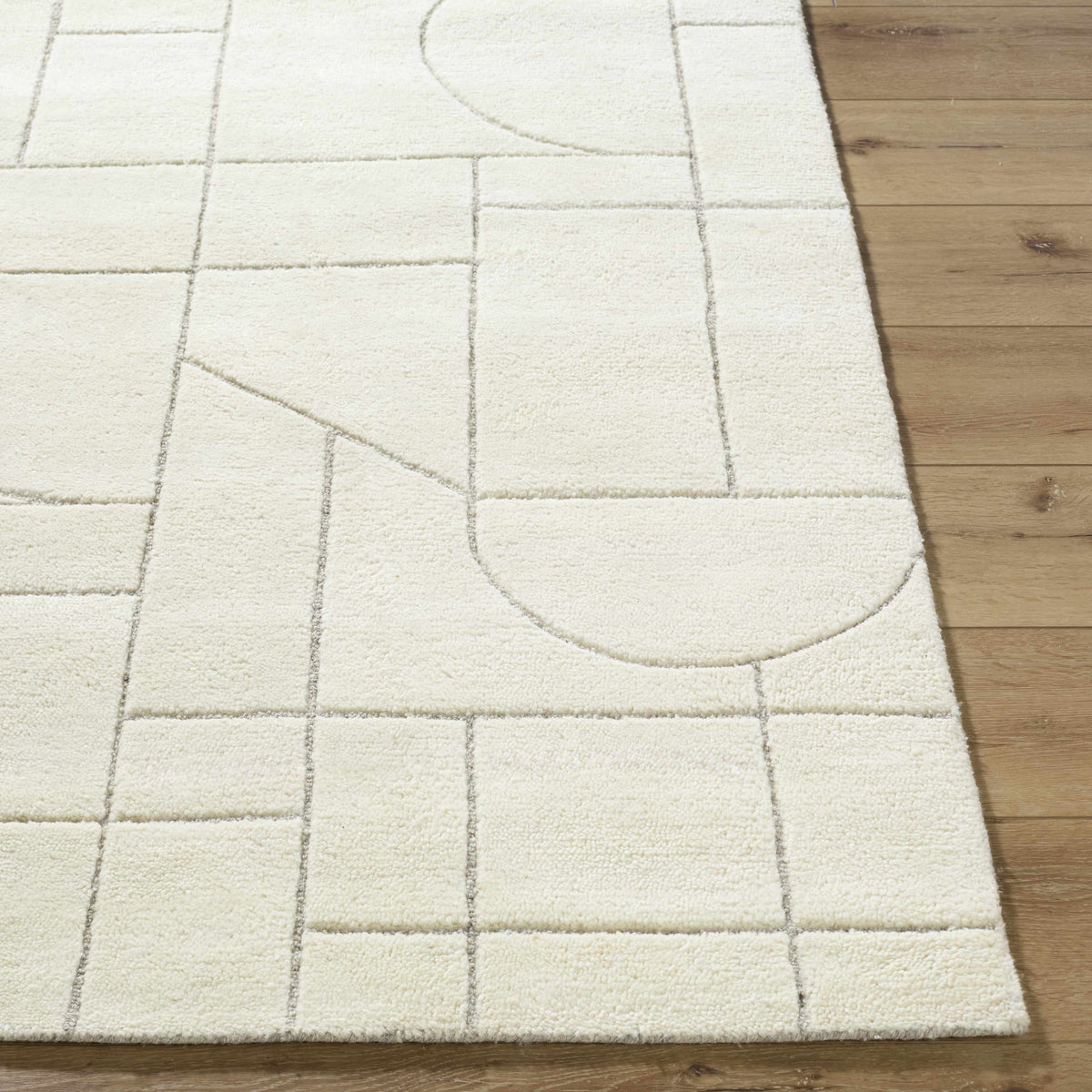 Boutique Rugs Fusao off white area rug with muted grid pattern on wood floor on Tampa Home & Garden Store