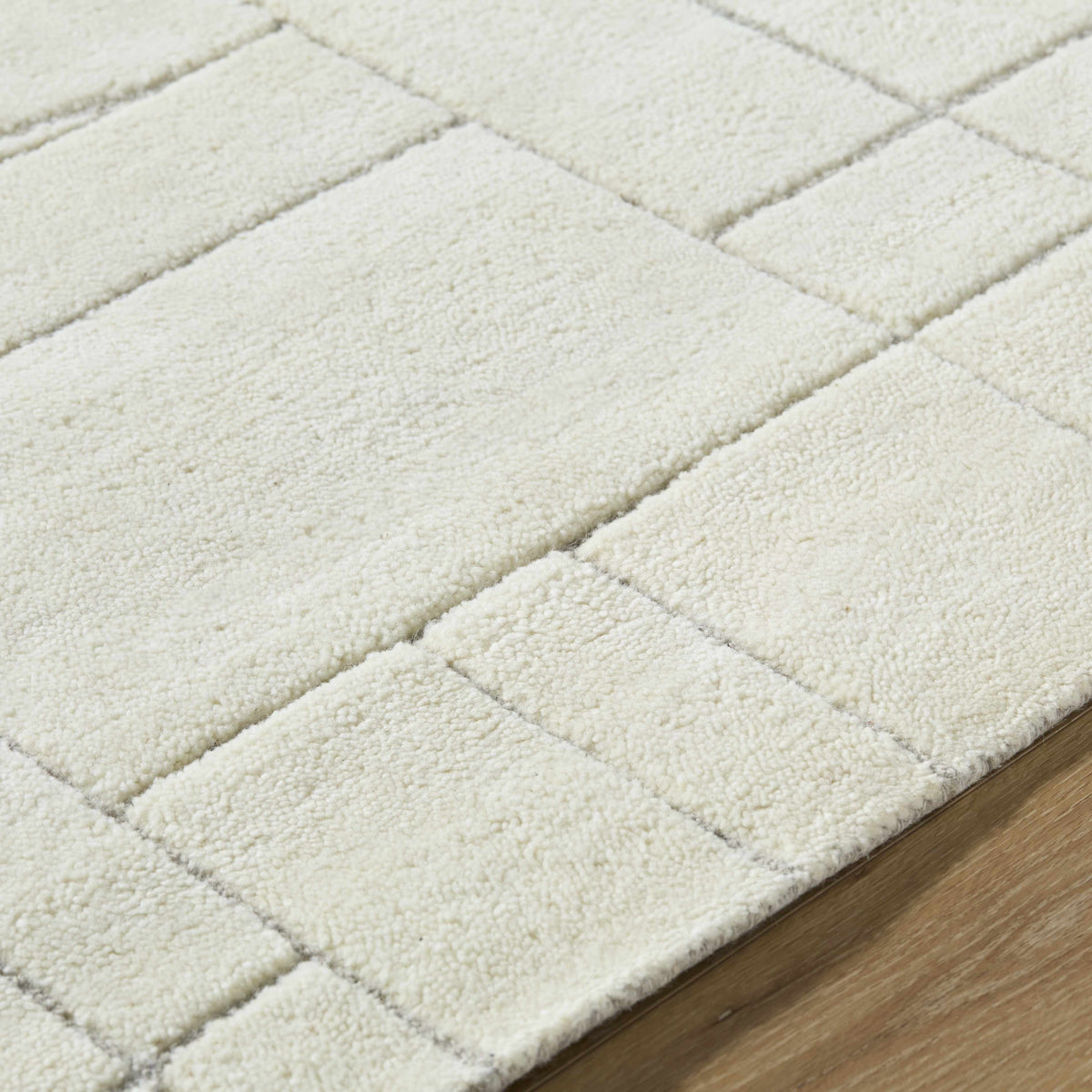 Fusao Off White Area Rug, plush shag with diamond pattern on wood floor on Tampa Home & Garden Store