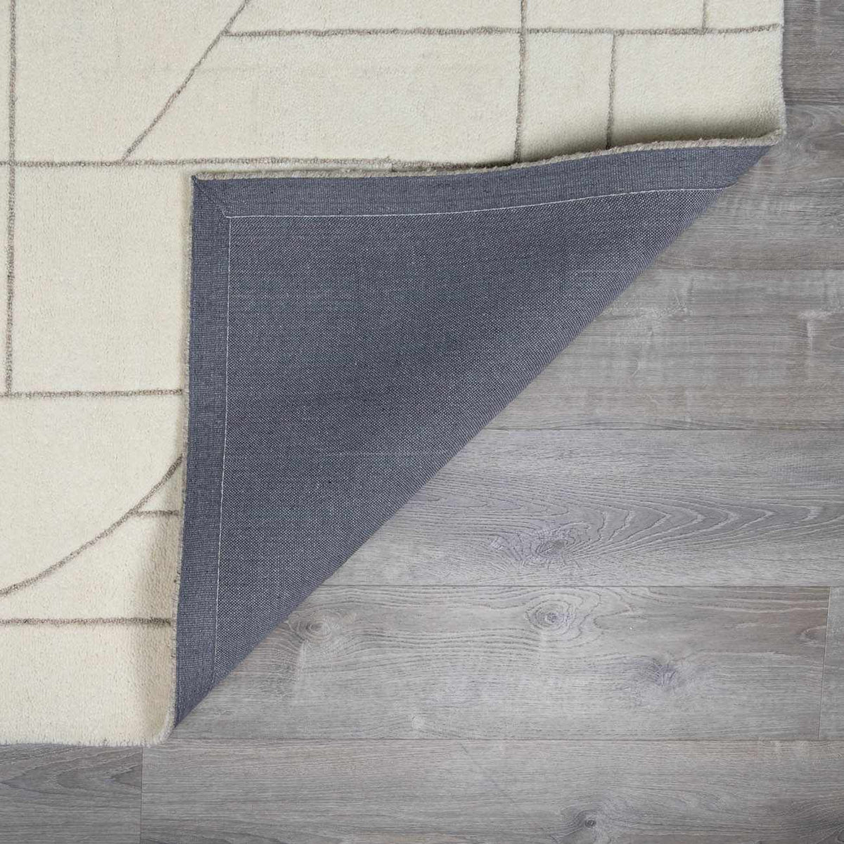 Fusao off-white area rug; cream surface with geometric lines; blue reverse backing on Tampa Home & Garden Store