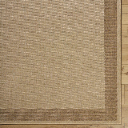 Inigo Flatweave Faux Jute Outdoor Rug, natural beige with brown border on wood floor on Tampa Home & Garden Store
