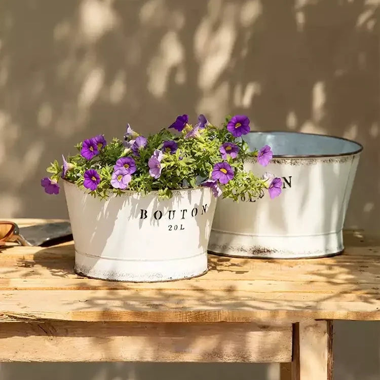 Two white vintage trough metal planters on a wooden table with purple petunias by RusticReach on Tampa Home & Garden Store