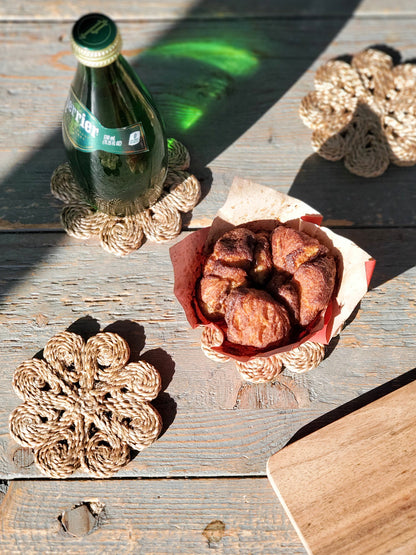 Jute Flower Drink Coaster Set of 4 natural rope coasters around a bottle and pastry on Tampa Home & Garden Store