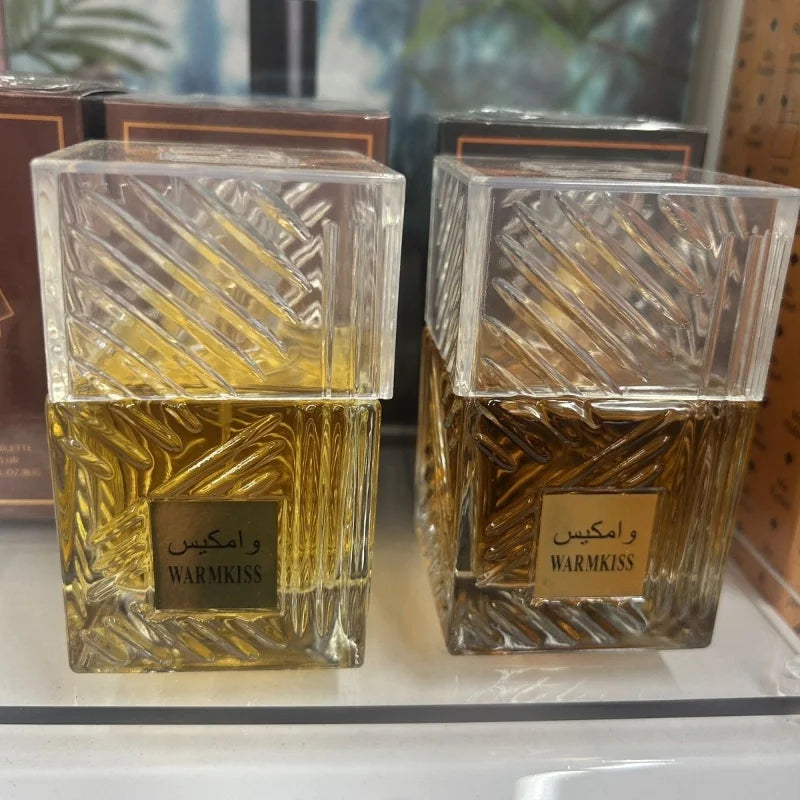 Warm Kiss perfume bottles: two clear square flacons with pattern, yellow and amber liquids on Tampa Home & Garden Store
