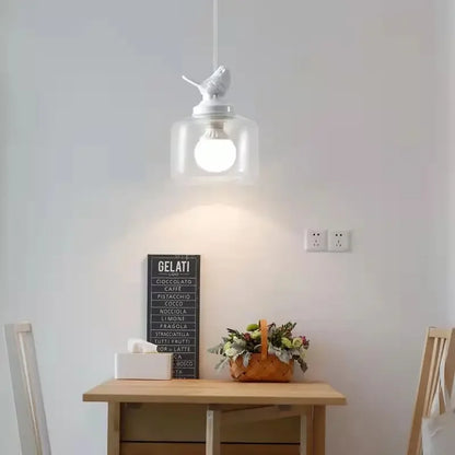 Birds glass pendant light with clear jar shade and white bird topper over a dining table on Tampa Home & Garden Store