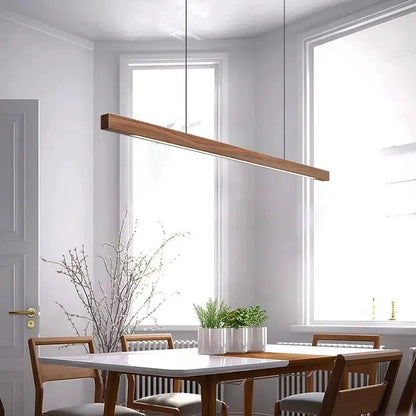 DecorBites Linear LED Pendant Light in wood finish over white dining table with plants on Tampa Home & Garden Store