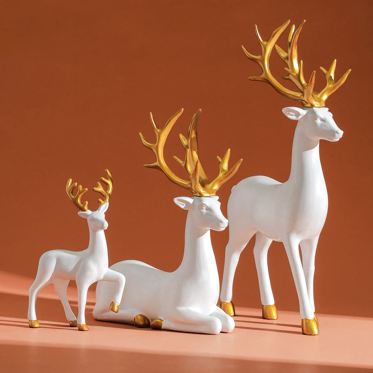 3-piece white resin reindeer figurine set with gold antlers, one lying and two standing on Tampa Home & Garden Store