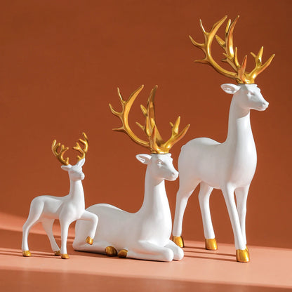 3-piece white resin reindeer figurine set with gold antlers, one lying and two standing on Tampa Home & Garden Store
