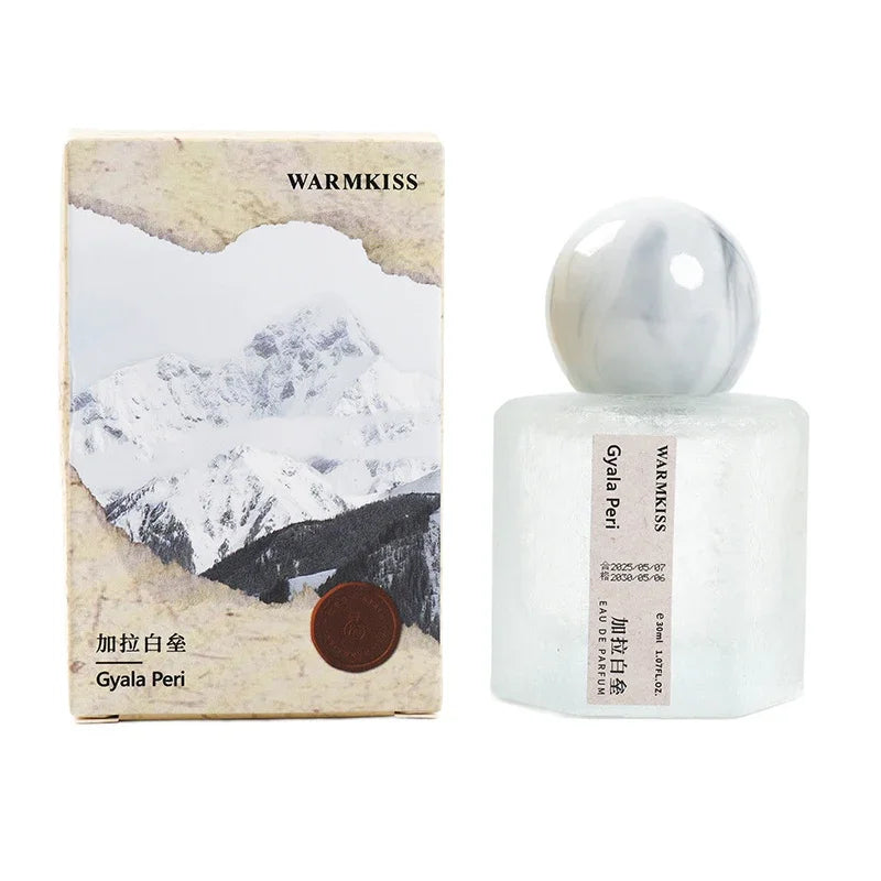 Frosted perfume bottle with marbled cap beside Warmkiss Gyala Peri box featuring artwork on Tampa Home & Garden Store