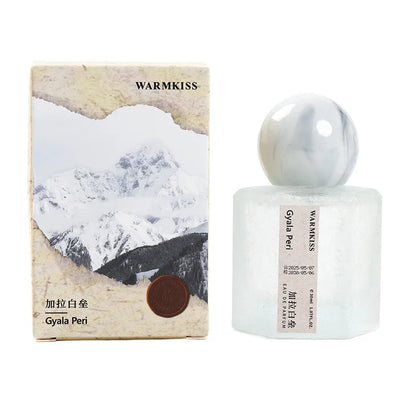 Frosted perfume bottle with marbled cap beside Warmkiss Gyala Peri box featuring artwork on Tampa Home & Garden Store