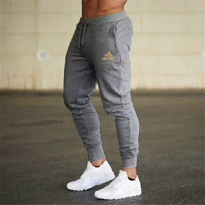 Men's gray joggers with drawstring and cuffed ankles, gold Adidas-style logo on thigh on Tampa Home & Garden Store