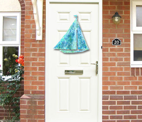 Sailboat garden stake by Rustica Ornamentals in turquoise blue metal hanging on front door on Tampa Home & Garden Store