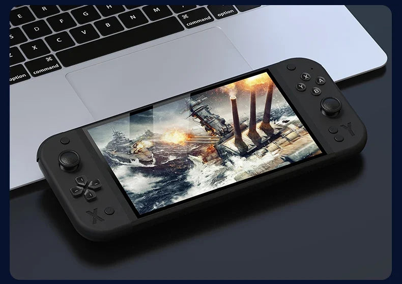 G90 handheld game console with 7-inch display, black plastic body beside a laptop on Tampa Home & Garden Store
