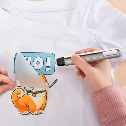 Cordless mini heat press in silver/black applying orange cat graphic with blue NO on white shirt on Tampa Home & Garden Store