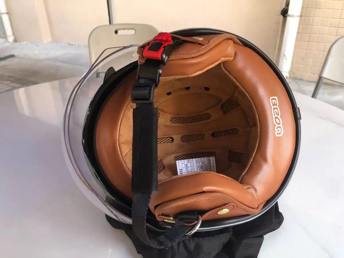 Retro motorcycle helmet open-face by BikerZoneZ with tan padding and red quick-release strap on Tampa Home & Garden Store