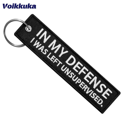 Left Unsupervised motorcycle keychain BikerZoneZ, black fabric tag with white embroidery on Tampa Home & Garden Store