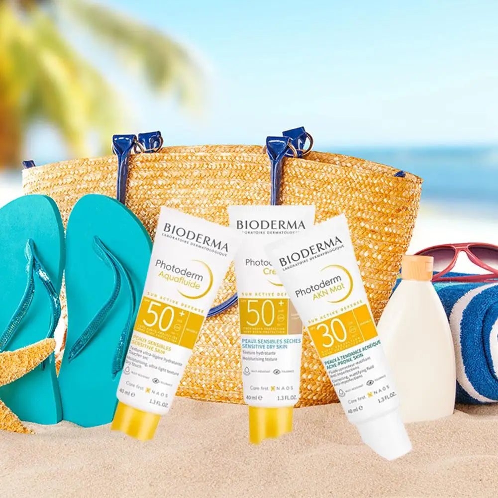 BIODERMA Photoderm sunscreen SPF50+ and SPF30 on a beach with a straw tote and flip-flops on Tampa Home & Garden Store