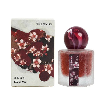 Perfume bottle with box, burgundy cap, frosted glass, Warmkiss Motuo Mist branding on Tampa Home & Garden Store