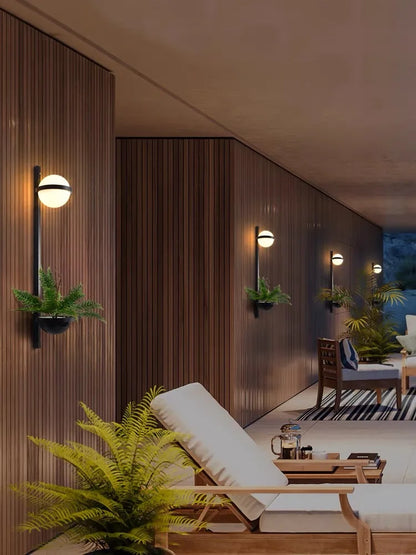 DecorBites LED Art Deco plant wall lights with globes on dark wood panels in outdoor area on Tampa Home & Garden Store
