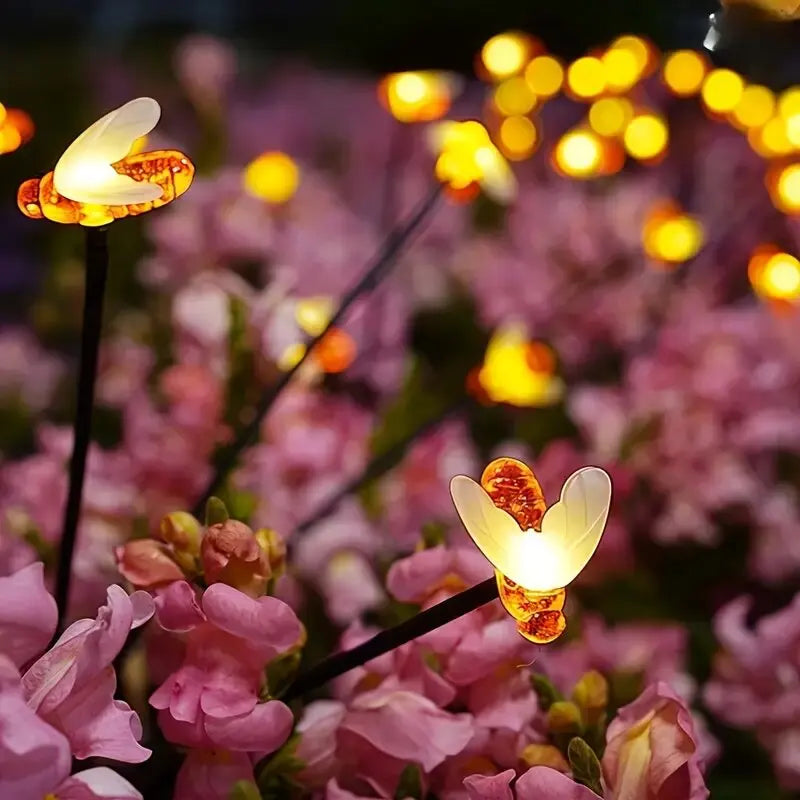 Perfecsy solar 6/8-head bee LED garden light with warm yellow glow on flowering backdrop on Tampa Home & Garden Store
