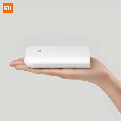 White portable mini photo printer in hand; 300dpi pocket printer with Xiaomi MI logo on Tampa Home & Garden Store