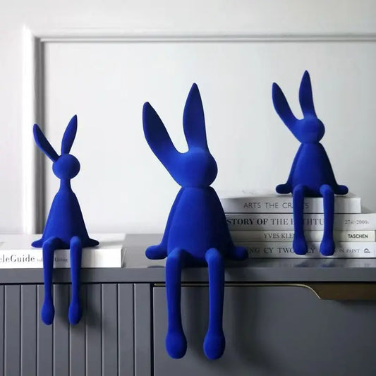 Blue resin flocked rabbit statue trio on shelf with books Perfecsy decor on Tampa Home & Garden Store