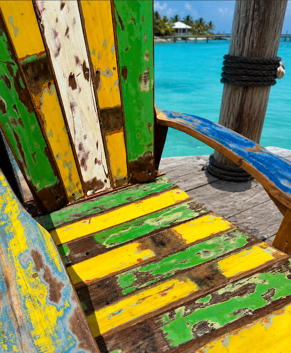 Recycled boat wood Adirondack rocking chair with multicolor worn paint on a weathered dock on Tampa Home & Garden Store