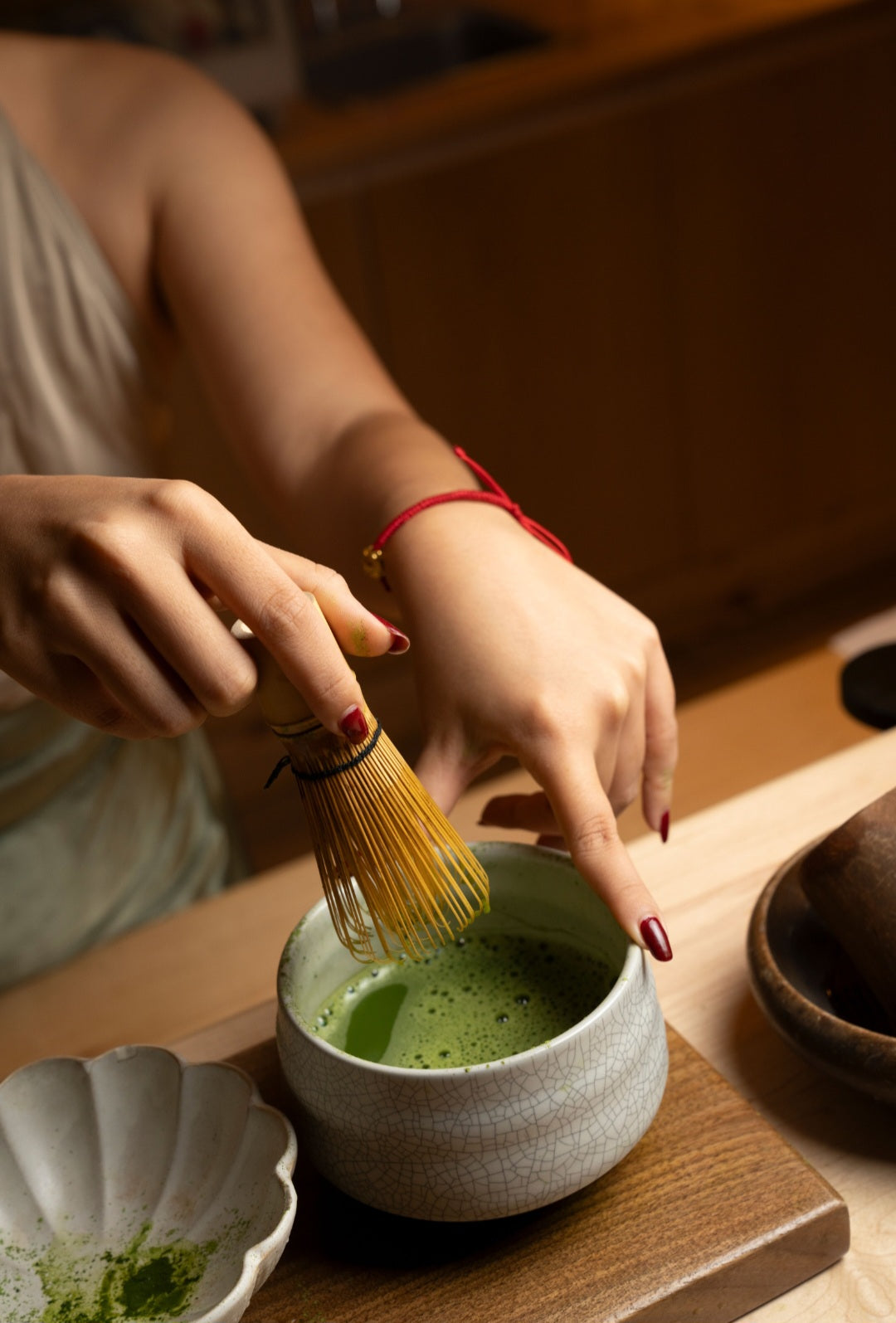 Bamboo Matcha Whisk (Chasen) in hand whisking green matcha in a ceramic bowl by isshiki matcha on Tampa Home & Garden Store
