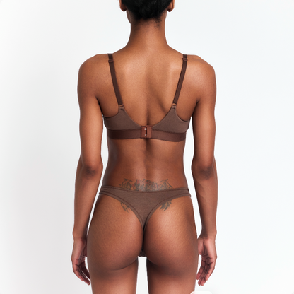Net Positive hemp thong in brown, back view on model showcasing low-rise fit on Tampa Home & Garden Store