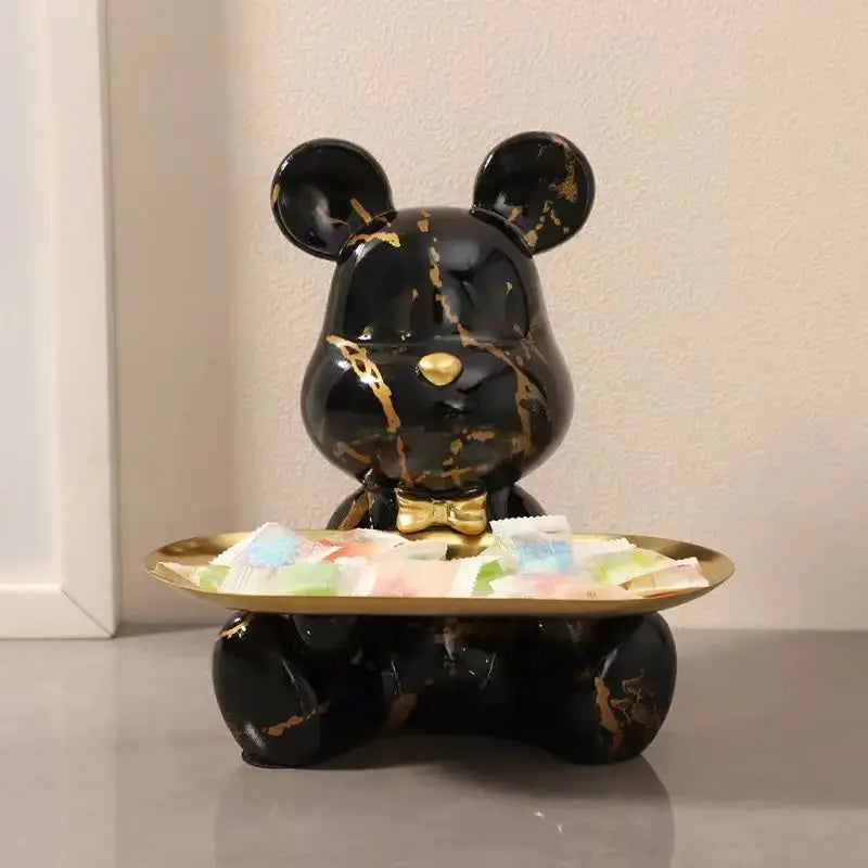 Graffiti bear figurine in black marble with gold veining holding a gold tray of packets on Tampa Home & Garden Store