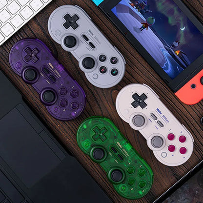 8Bitdo SN30 Pro Bluetooth gamepad quartet in translucent purple, gray, white, and green on desk on Tampa Home & Garden Store