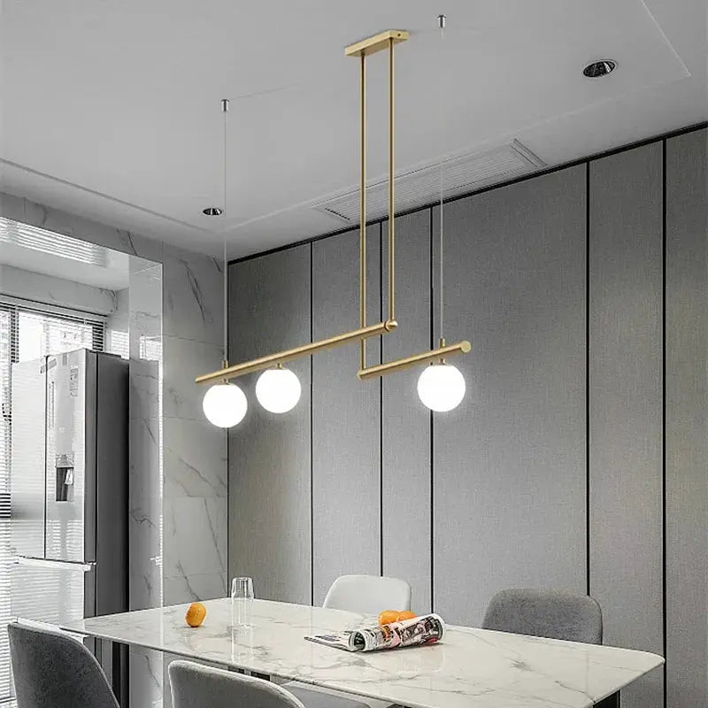 DecorBites linear chandelier pendant light in gold finish with three globe bulbs over marble on Tampa Home & Garden Store